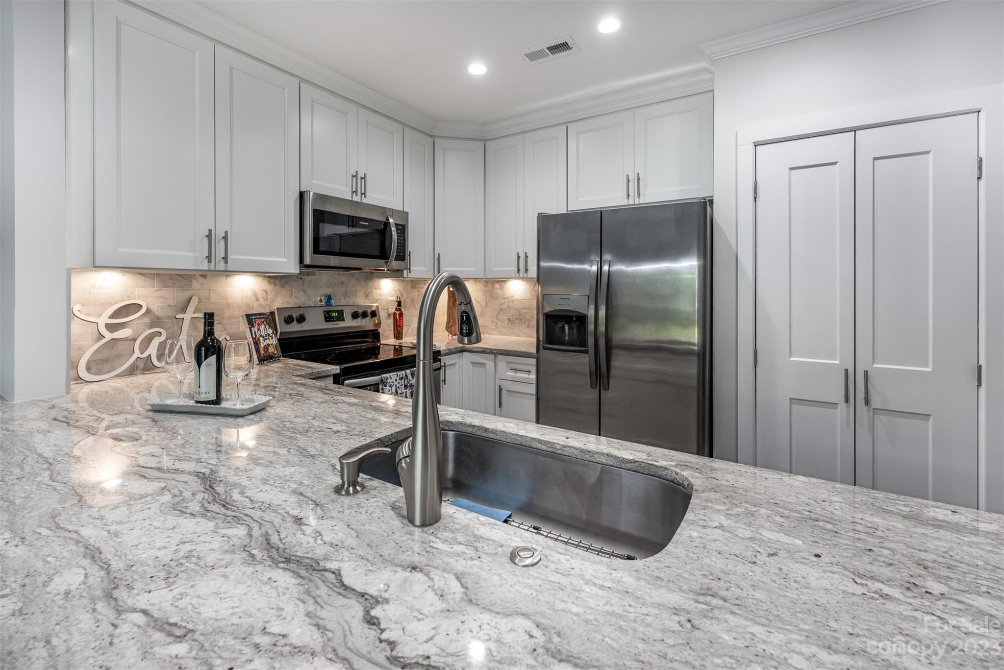 20101 Henderson Road, Unit H Cornelius, NC 28031 - Photo 15 of 48 a kitchen with granite countertop a refrigerator and a sink