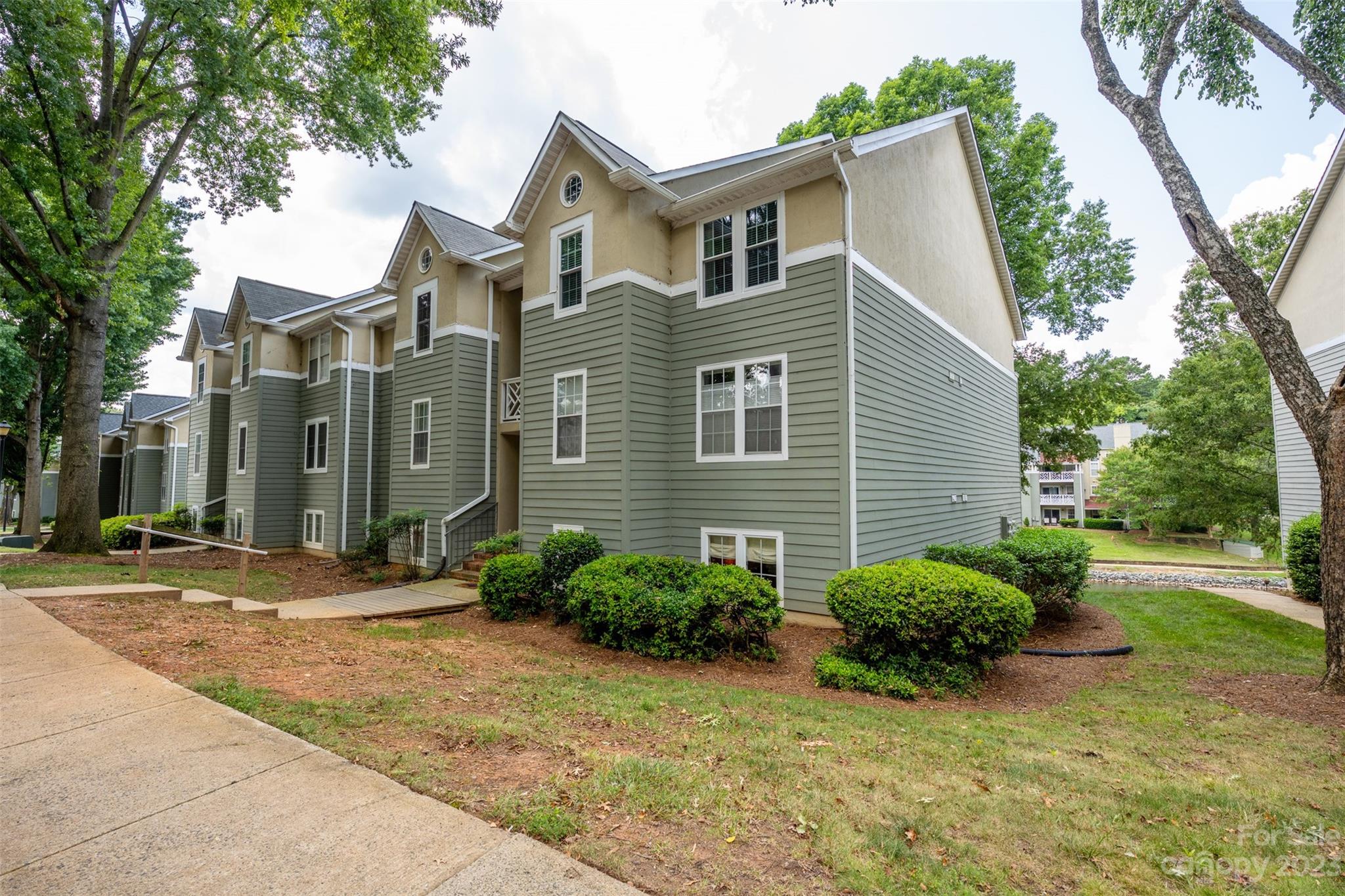 20101 Henderson Road, Unit H Cornelius, NC 28031 - Photo 3 of 48 a view of a yard in front of a brick house with large windows
