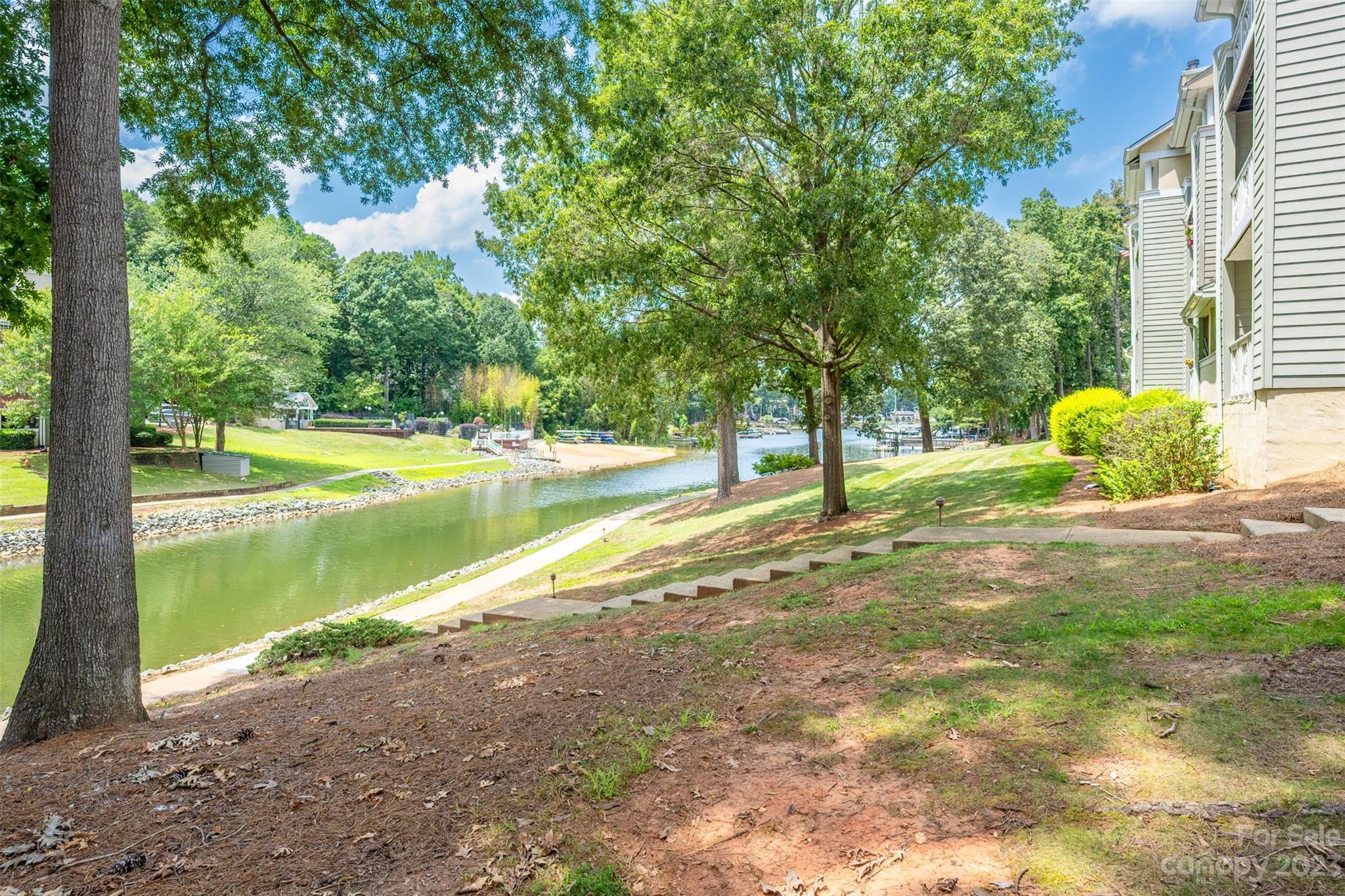 20101 Henderson Road, Unit H Cornelius, NC 28031 - Photo 32 of 48 a view of a lake with a yard and a large tree