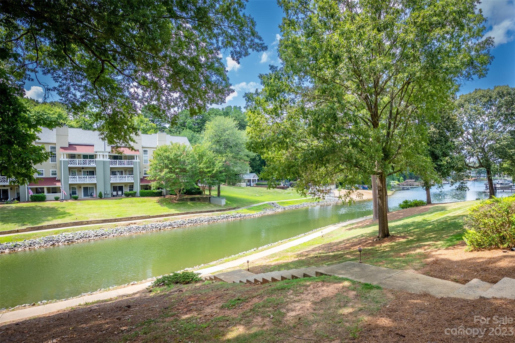 20101 Henderson Road, Unit H Cornelius, NC 28031 - Photo 34 of 48 a view of a swimming pool with a yard and large trees