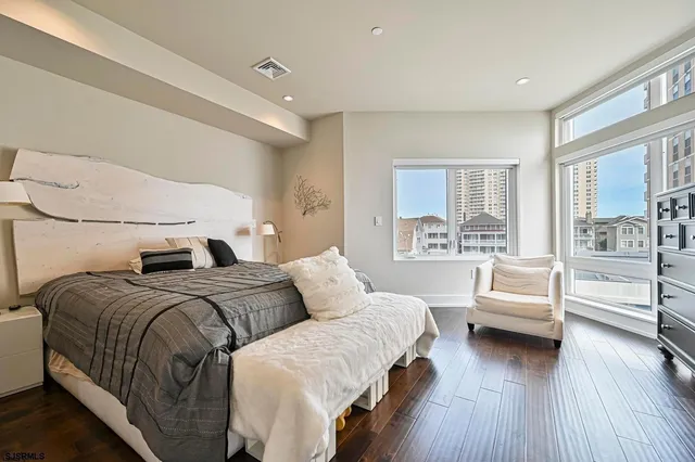 a bedroom with a large bed and a wooden floor