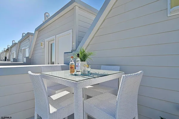 a roof deck with table and chairs under an umbrella