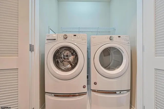 a view of an empty room with chandelier fan