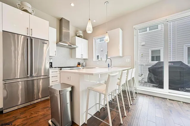 a kitchen with a dining table chairs refrigerator and cabinets