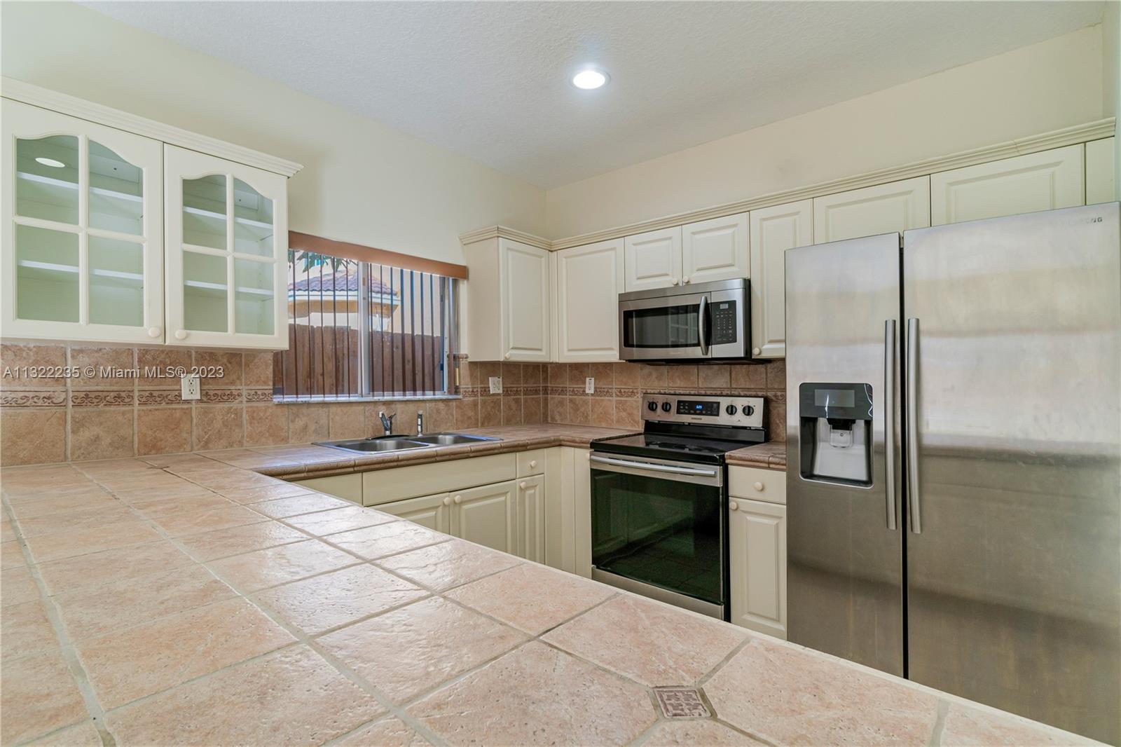 13040 Southwest 142nd Terrace Miami, FL 33186 - Photo 15 of 26 a kitchen with stainless steel appliances granite countertop a stove a sink and a refrigerator