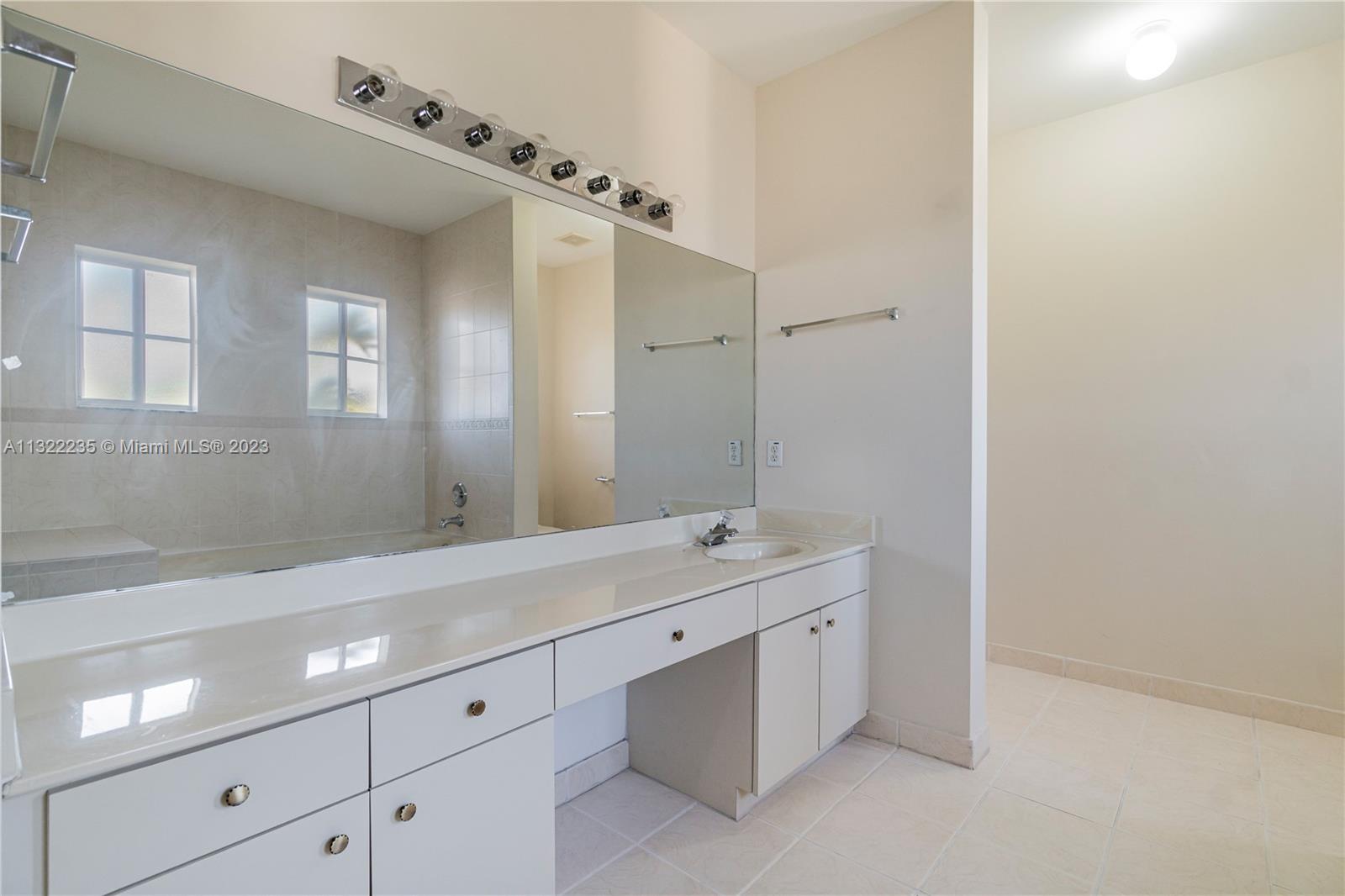 13040 Southwest 142nd Terrace Miami, FL 33186 - Photo 19 of 26 a spacious bathroom with a double vanity sink a mirror and a shower