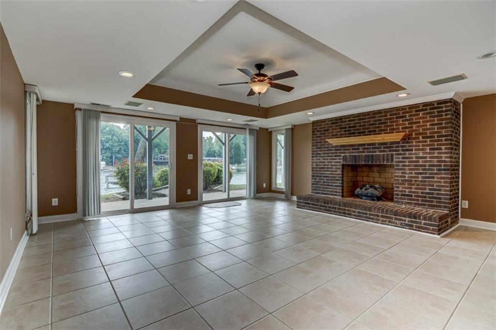 3972 Lake Shore Road South Denver, NC 28037 - Photo 18 of 48 a view of an empty room with a fireplace and a ceiling fan