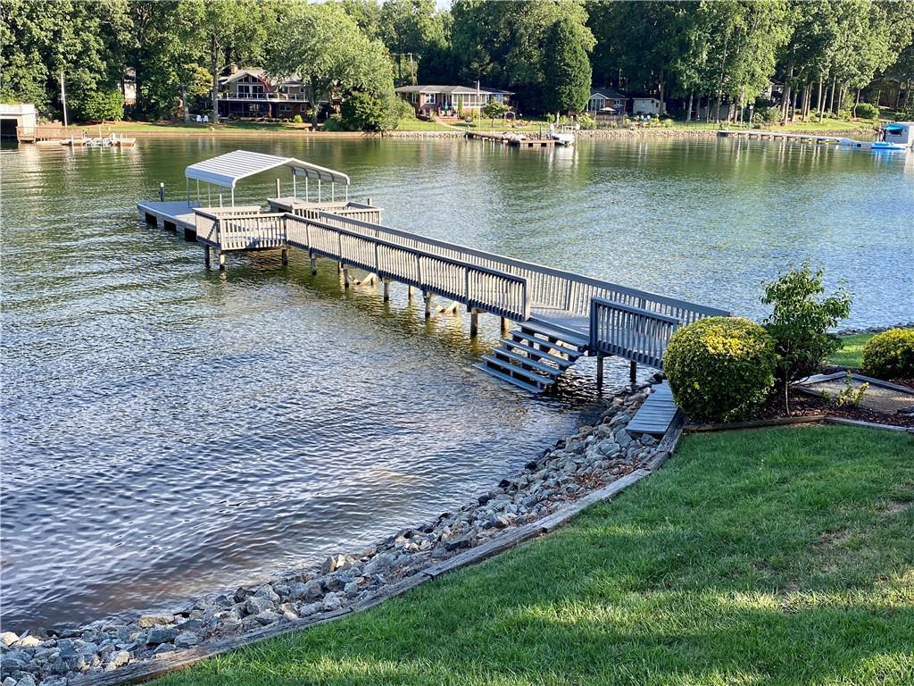 3972 Lake Shore Road South Denver, NC 28037 - Photo 7 of 48 a view of a lake with a bench and trees in the background
