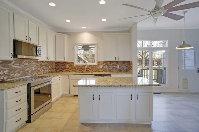 a kitchen with granite countertop a sink stainless steel appliances and cabinets