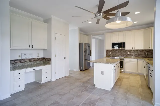 a kitchen with granite countertop a sink stove and refrigerator