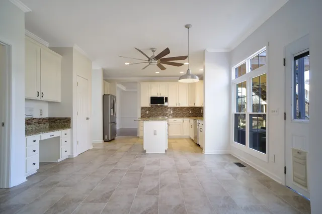 a open kitchen with granite countertop a stove top oven a sink and a refrigerator