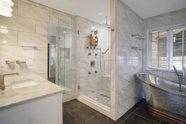 a bathroom with a granite countertop shower a mirror and a sink