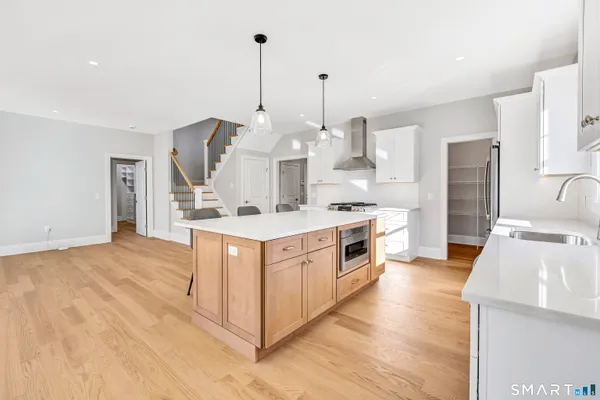 a kitchen with stainless steel appliances kitchen island granite countertop a sink a stove and a refrigerator