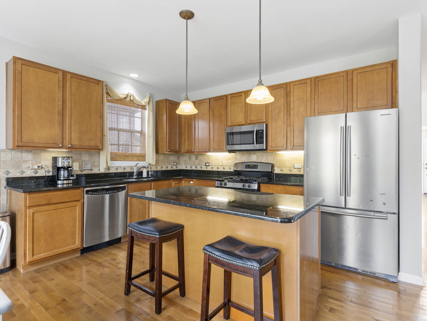 26528 Rustling Birch Way Plainfield, IL 60585 - Photo 8 of 39 a kitchen with stainless steel appliances granite countertop a refrigerator a sink dishwasher a stove and white cabinets with wooden floor