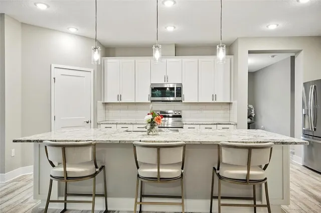 a kitchen with kitchen island granite countertop a sink stove and wooden cabinets