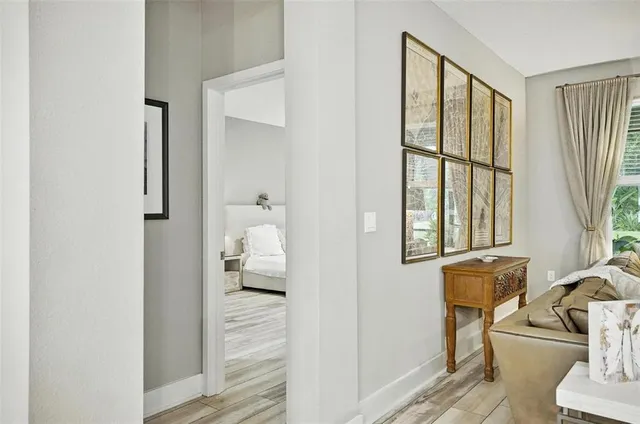 a bedroom with a large bed a flat tv screen and a chandelier