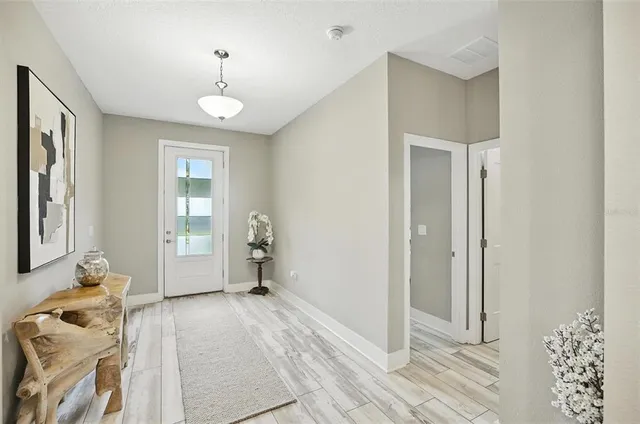 a kitchen with kitchen island a white table chairs refrigerator and cabinets
