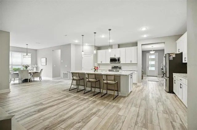 a kitchen with stainless steel appliances granite countertop a sink stove microwave and refrigerator