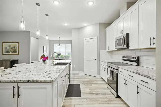 a living room with granite countertop kitchen island furniture and a flat screen tv