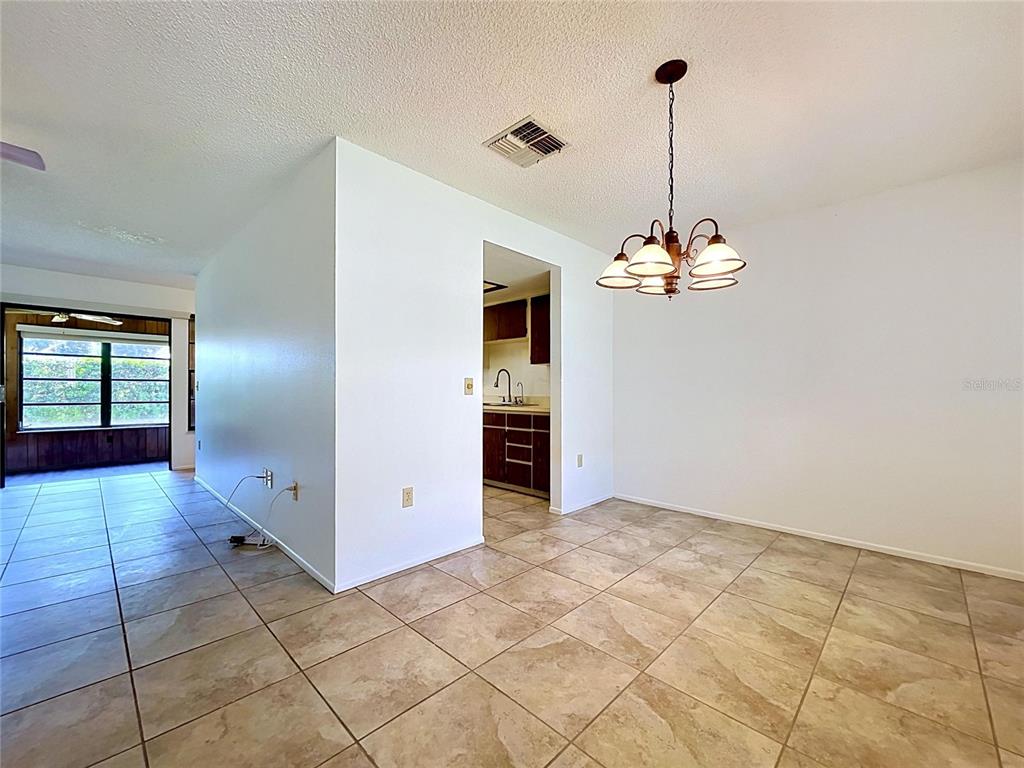 9319 Trowbridge Court New Port Richey, FL 34655 - Photo 26 of 78 a view of an empty room with window and chandelier