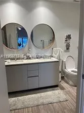 a bathroom with a granite countertop sink a toilet and a mirror