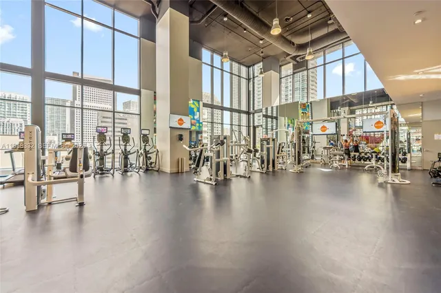 a view of a room with lots of wooden furniture and floor to ceiling windows