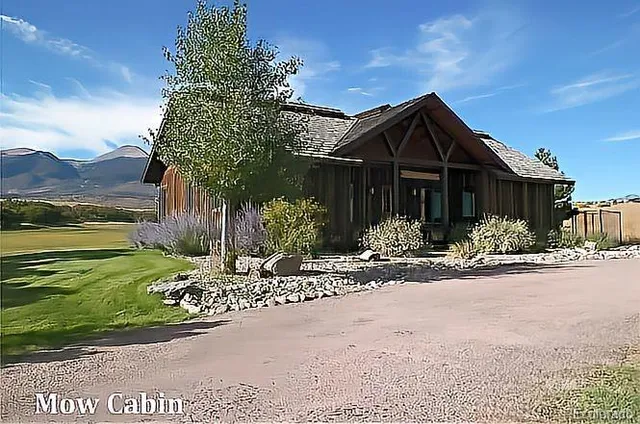 a view of a lake with a yard and large trees