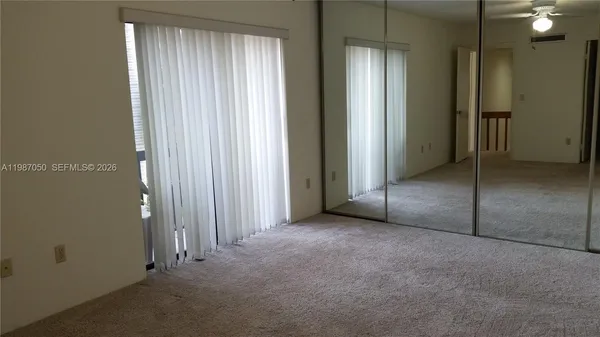 an empty room with windows and closet