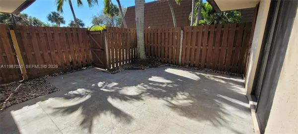 a view of backyard with wooden fence