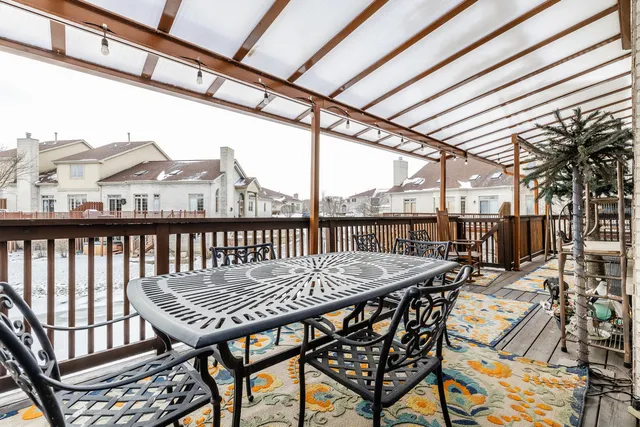 a view of a roof deck with table and chairs and wooden floor