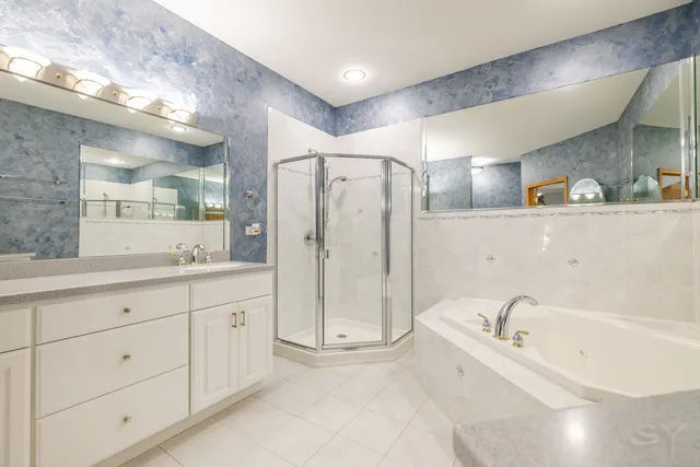 a spacious bathroom with a tub sink and mirror