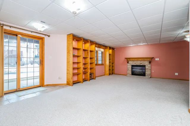 a view of an empty room with a fireplace and a window