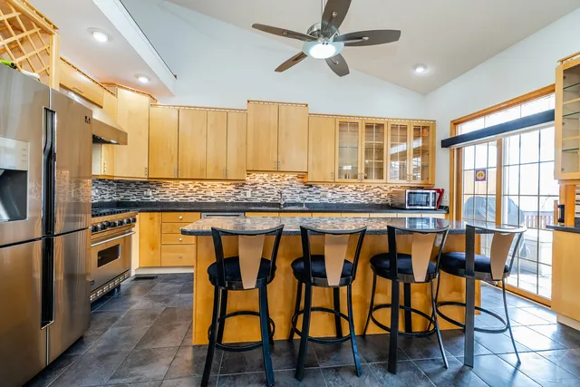 a kitchen with stainless steel appliances granite countertop a stove a sink and a refrigerator