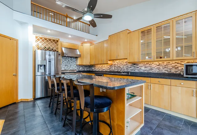 a kitchen with stainless steel appliances granite countertop a sink and a refrigerator