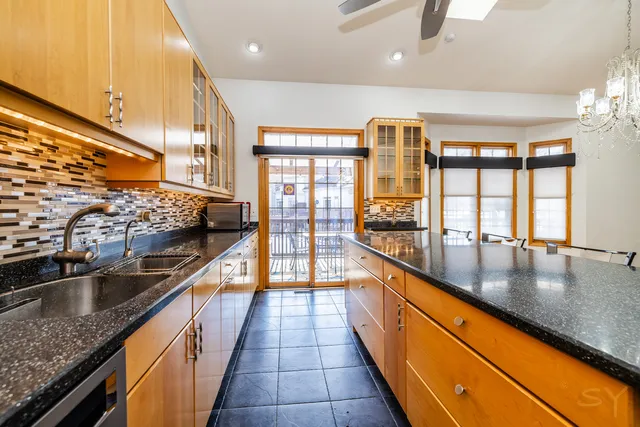 a large kitchen with stainless steel appliances granite countertop sink stove and refrigerator