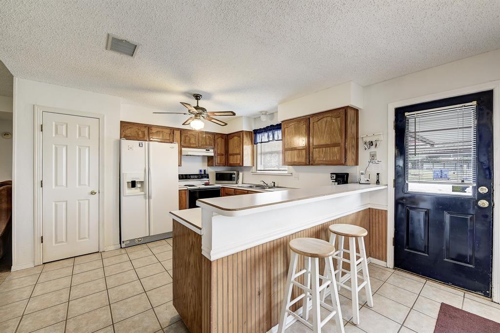 365 Country Lane Haslet, TX 76052 - Photo 11 of 34 a kitchen with stainless steel appliances a stove refrigerator sink and cabinets