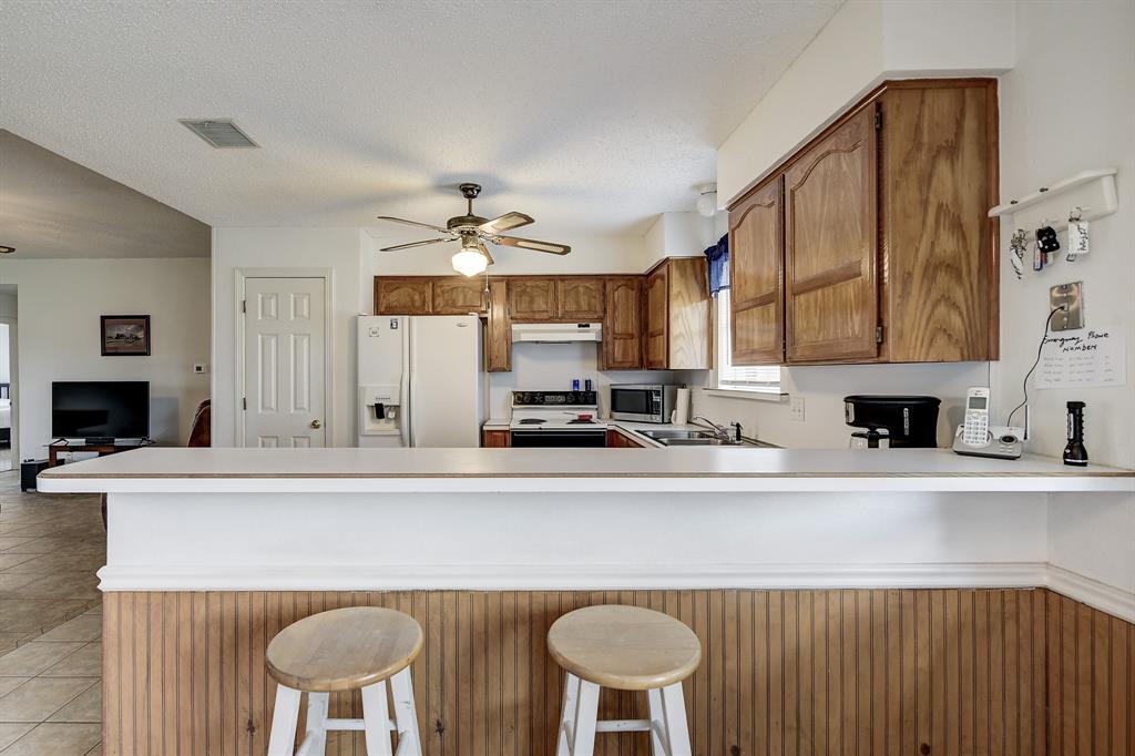 365 Country Lane Haslet, TX 76052 - Photo 12 of 34 a kitchen with stainless steel appliances kitchen island a table and chairs