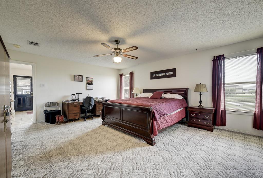 365 Country Lane Haslet, TX 76052 - Photo 17 of 34 a spacious bedroom with a bed a couch and a chandelier