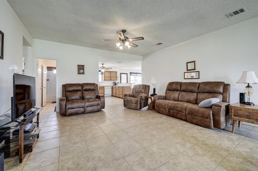 365 Country Lane Haslet, TX 76052 - Photo 3 of 34 a living room with furniture a ceiling fan and a flat screen tv