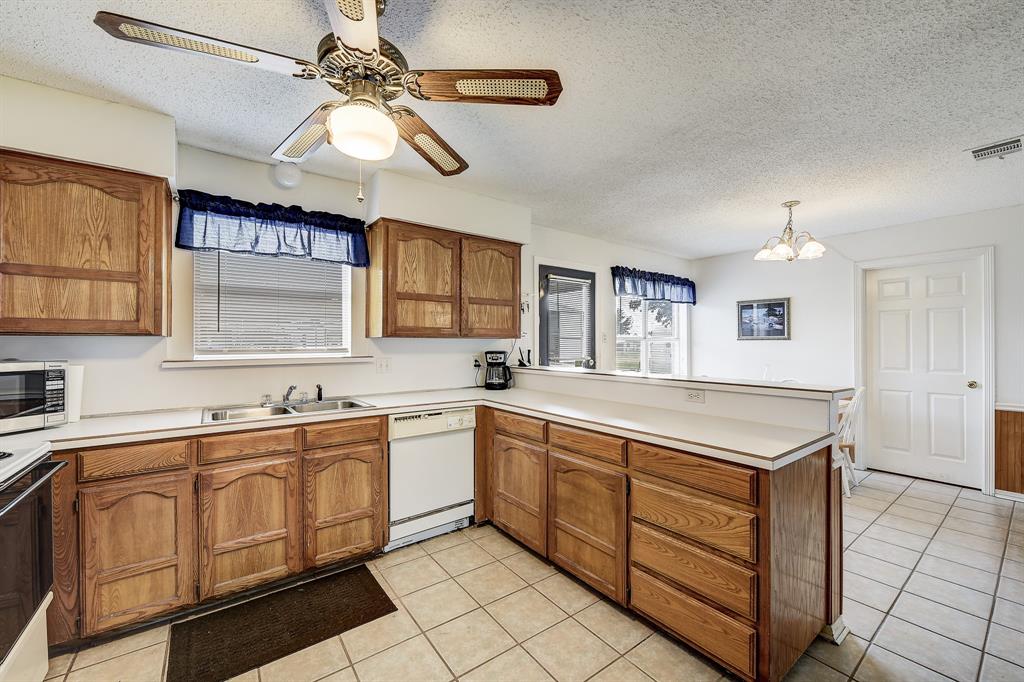 365 Country Lane Haslet, TX 76052 - Photo 10 of 34 a view of a kitchen counter space a sink stainless steel appliances and cabinets