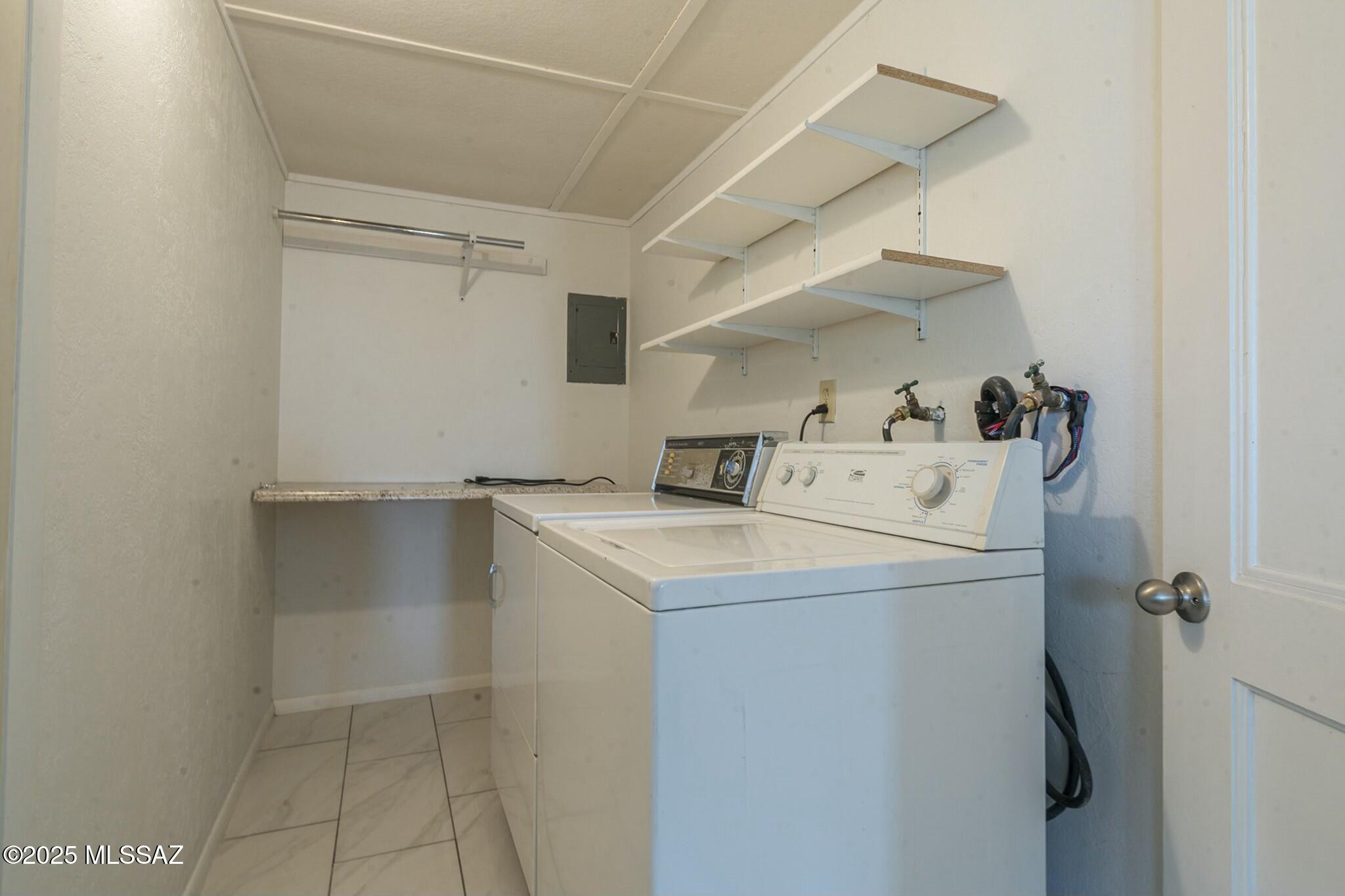 5850 West Box R Street Tucson, AZ 85713 - Photo 9 of 29 Laundry room features washer and dryer with a folding table at the end.