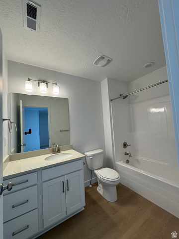 1876 West 1575th North, Unit 237 Layton, UT 84041 - Photo 13 of 20 Bathroom featuring vanity, a textured ceiling, dark wood-type flooring, and washtub / shower combination
