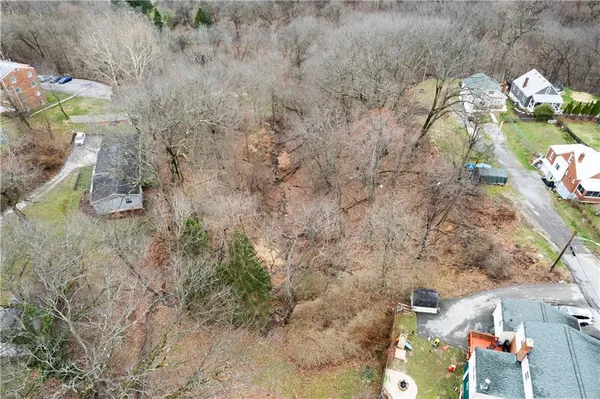 a aerial view of a house with a yard and large trees