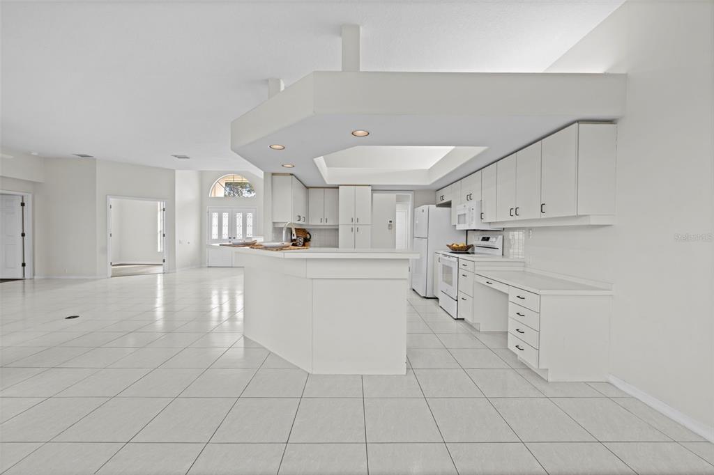 9369 Ashley Drive Weeki Wachee, FL 34613 - Photo 14 of 80 a kitchen with white cabinets and white appliances