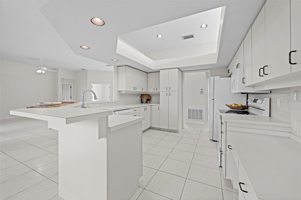 9369 Ashley Drive Weeki Wachee, FL 34613 - Photo 18 of 80 a kitchen with white cabinets and appliances
