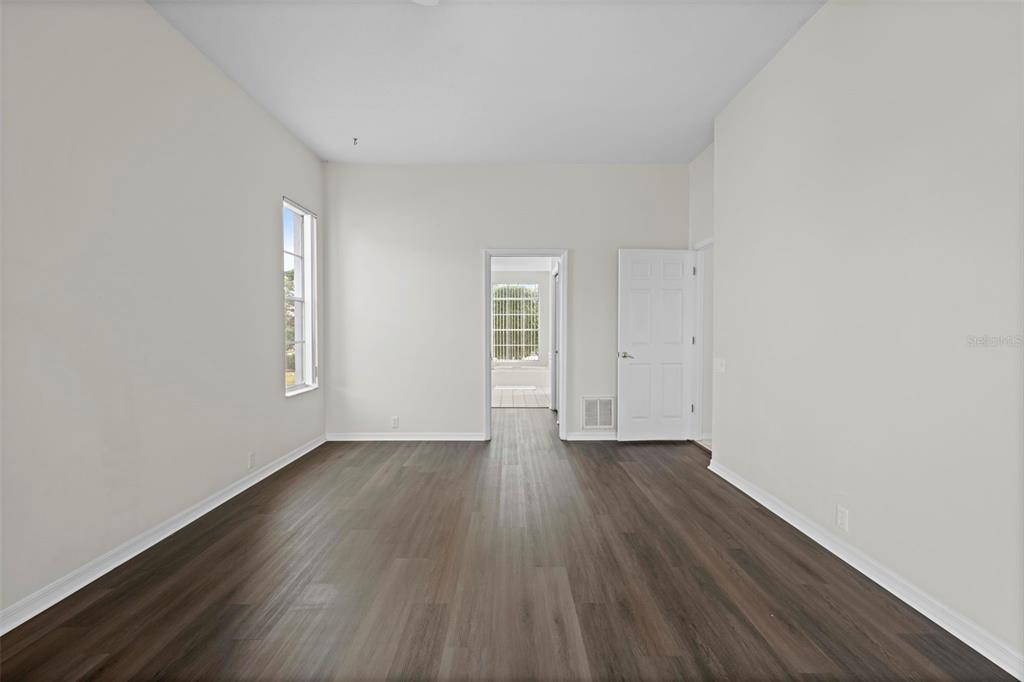 9369 Ashley Drive Weeki Wachee, FL 34613 - Photo 27 of 80 an empty room with wooden floor and windows