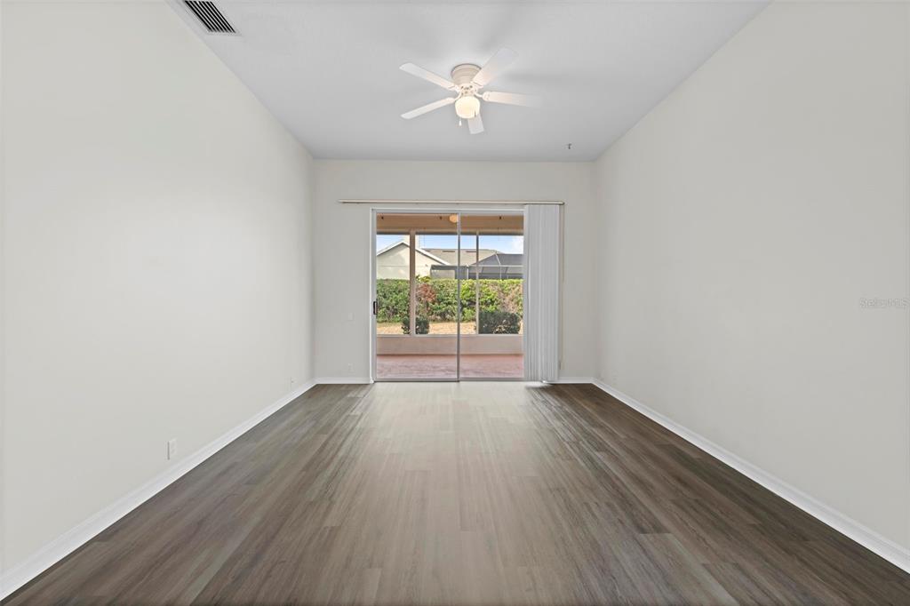 9369 Ashley Drive Weeki Wachee, FL 34613 - Photo 29 of 80 an empty room with wooden floor and windows