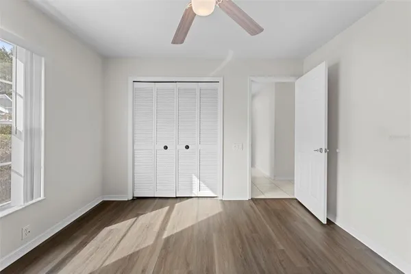 a view of a white house with a large trees and plants