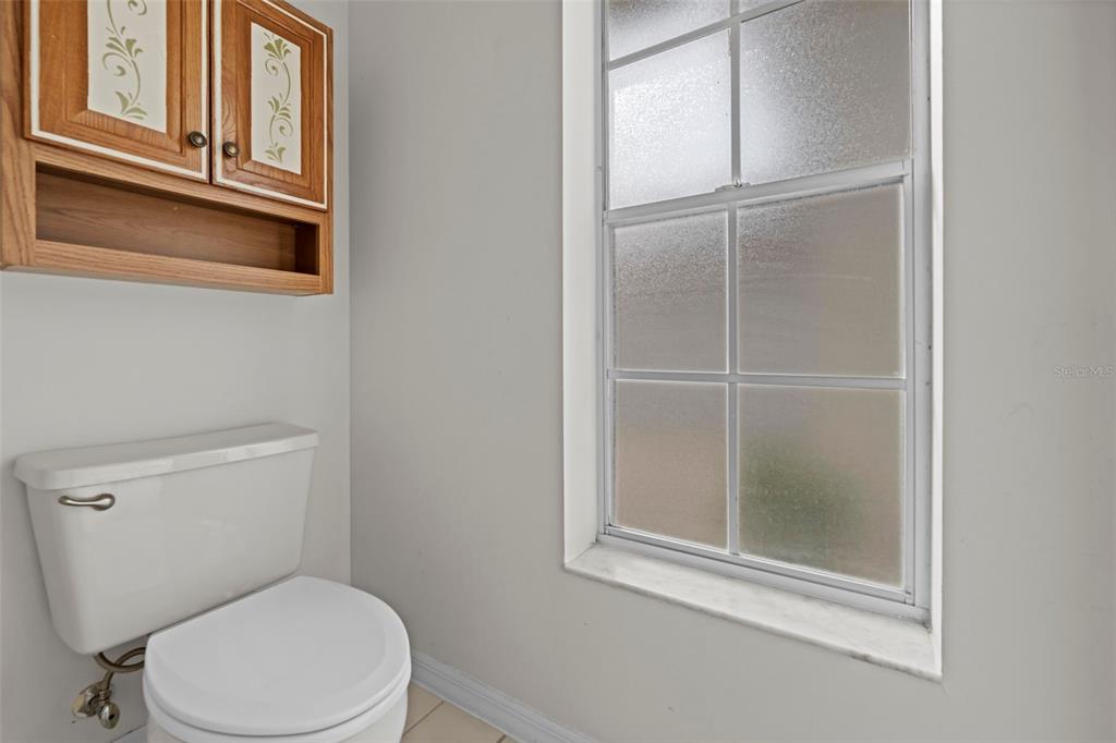 9369 Ashley Drive Weeki Wachee, FL 34613 - Photo 45 of 80 a white toilet sitting next to a window