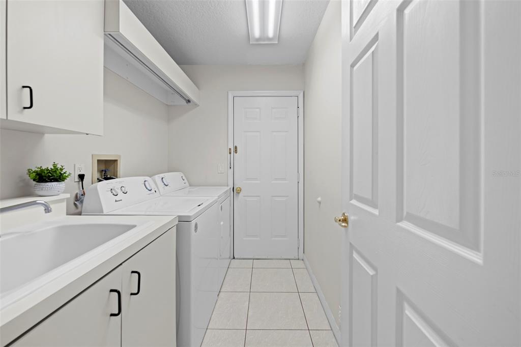 9369 Ashley Drive Weeki Wachee, FL 34613 - Photo 46 of 80 a utility room with cabinets washer and dryer